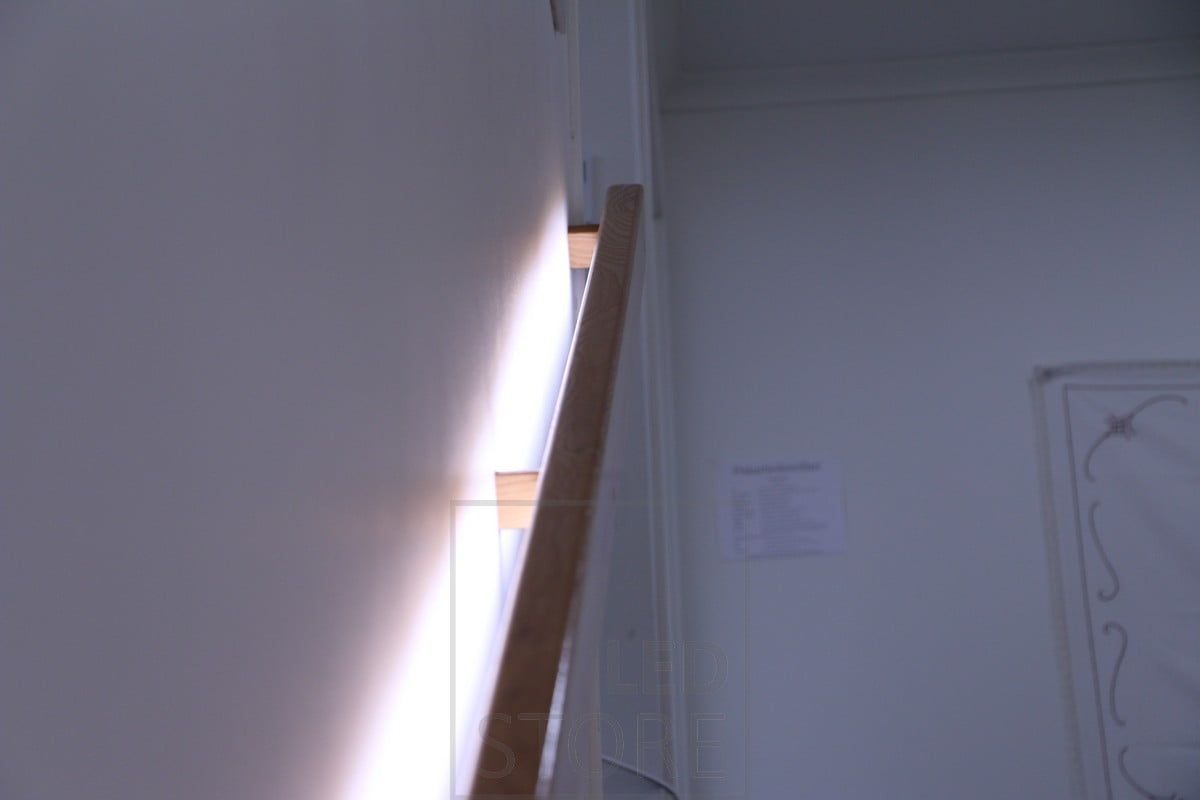 Wall mounted led strip on a handrail, giving a really soft light when illuminated through the wall